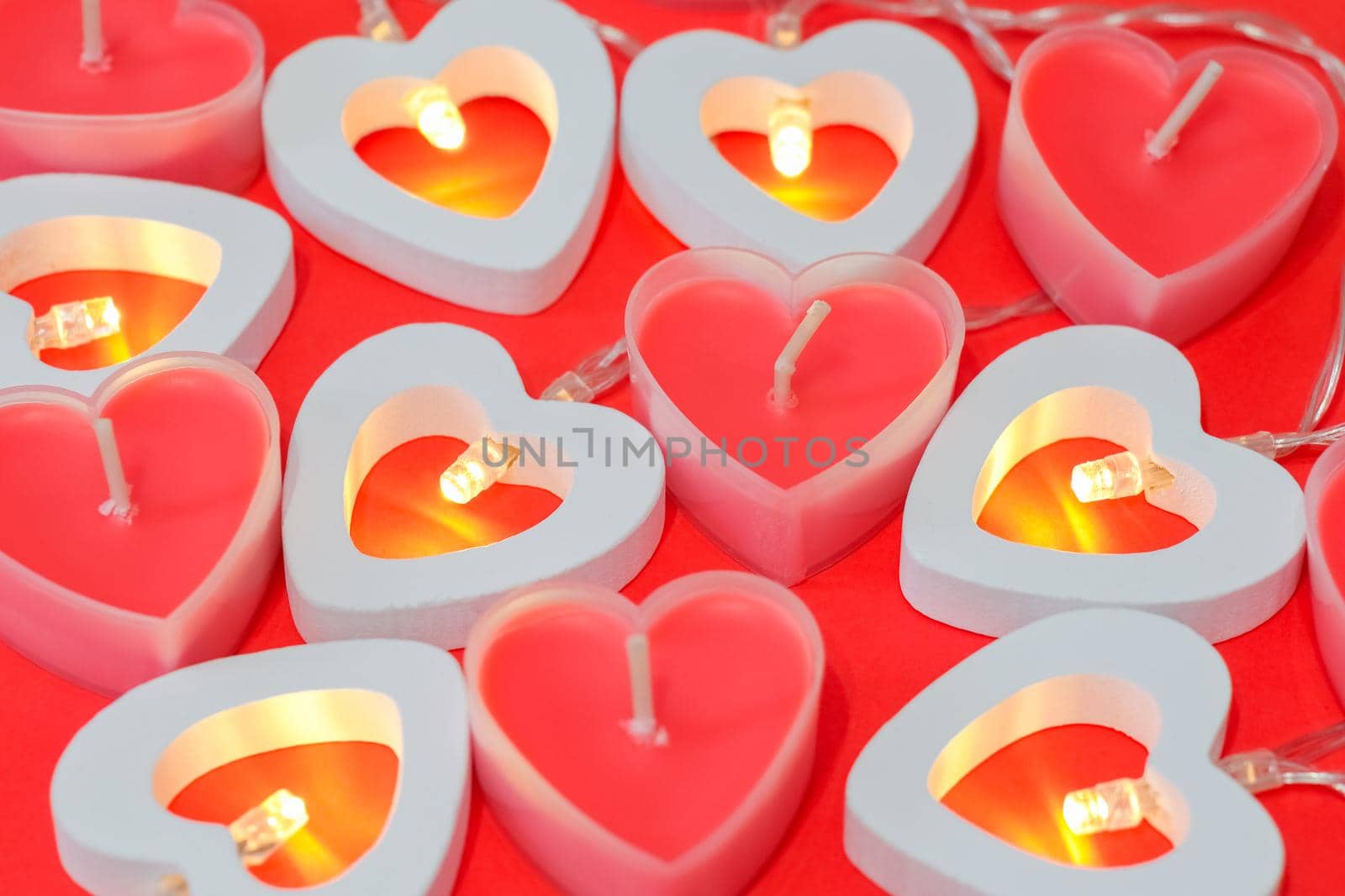pink candles in the form of a heart on a red background for Valentine's day  by roman112007