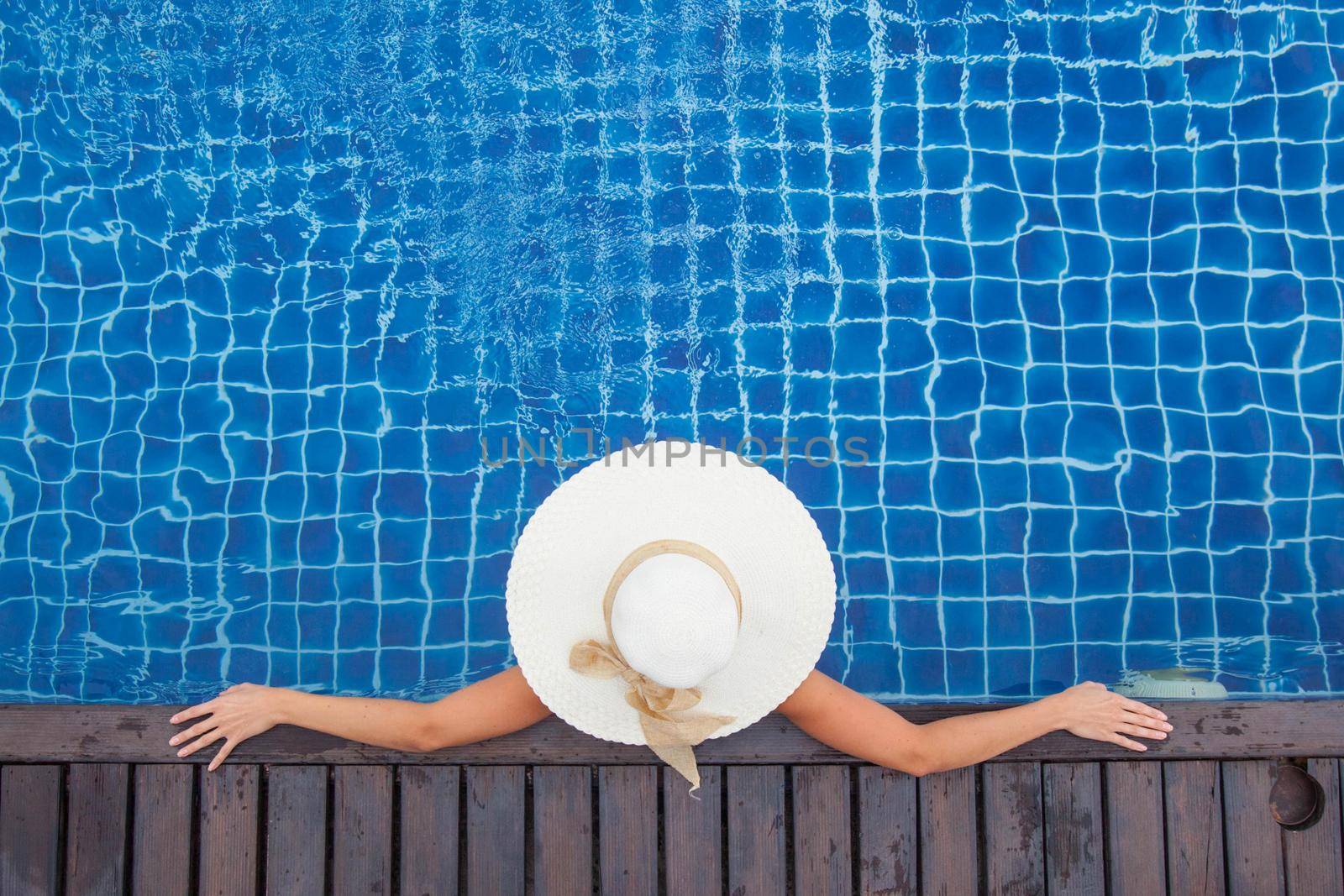 Woman sunbathing by the pool by Yellowj