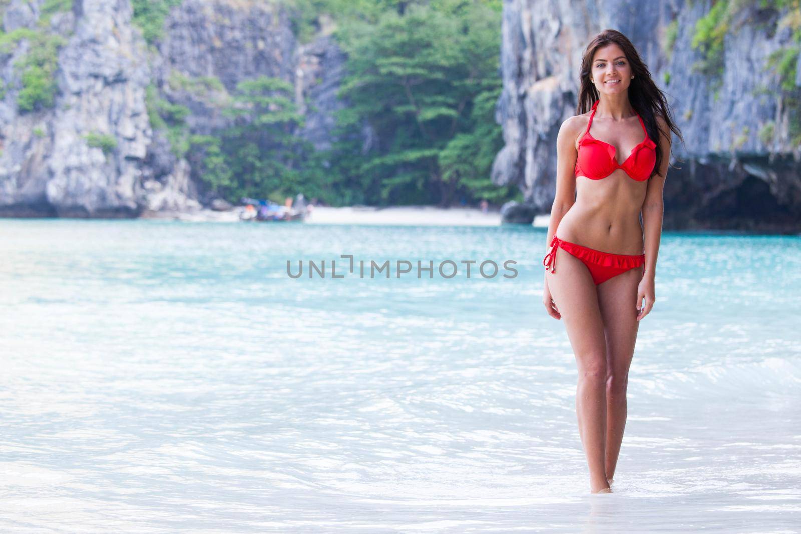 Woman walking on beach by Yellowj