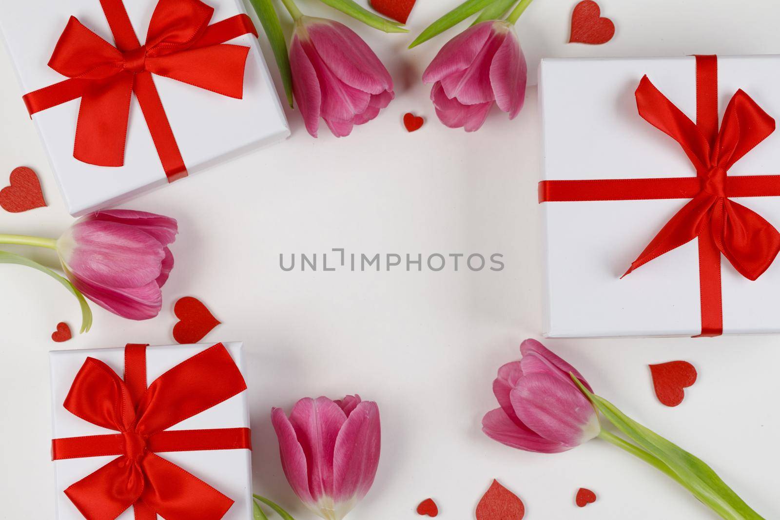 Pink tulips gifts and hearts border frame with copy space isolated on white background Valentines day concept