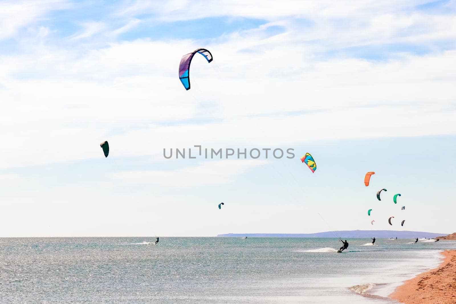 a kitesurfer surfing on the smooth azure water. recreational sport. A Man Rides A Kiteboarding In The Sea Water. extreme sport. High quality photo