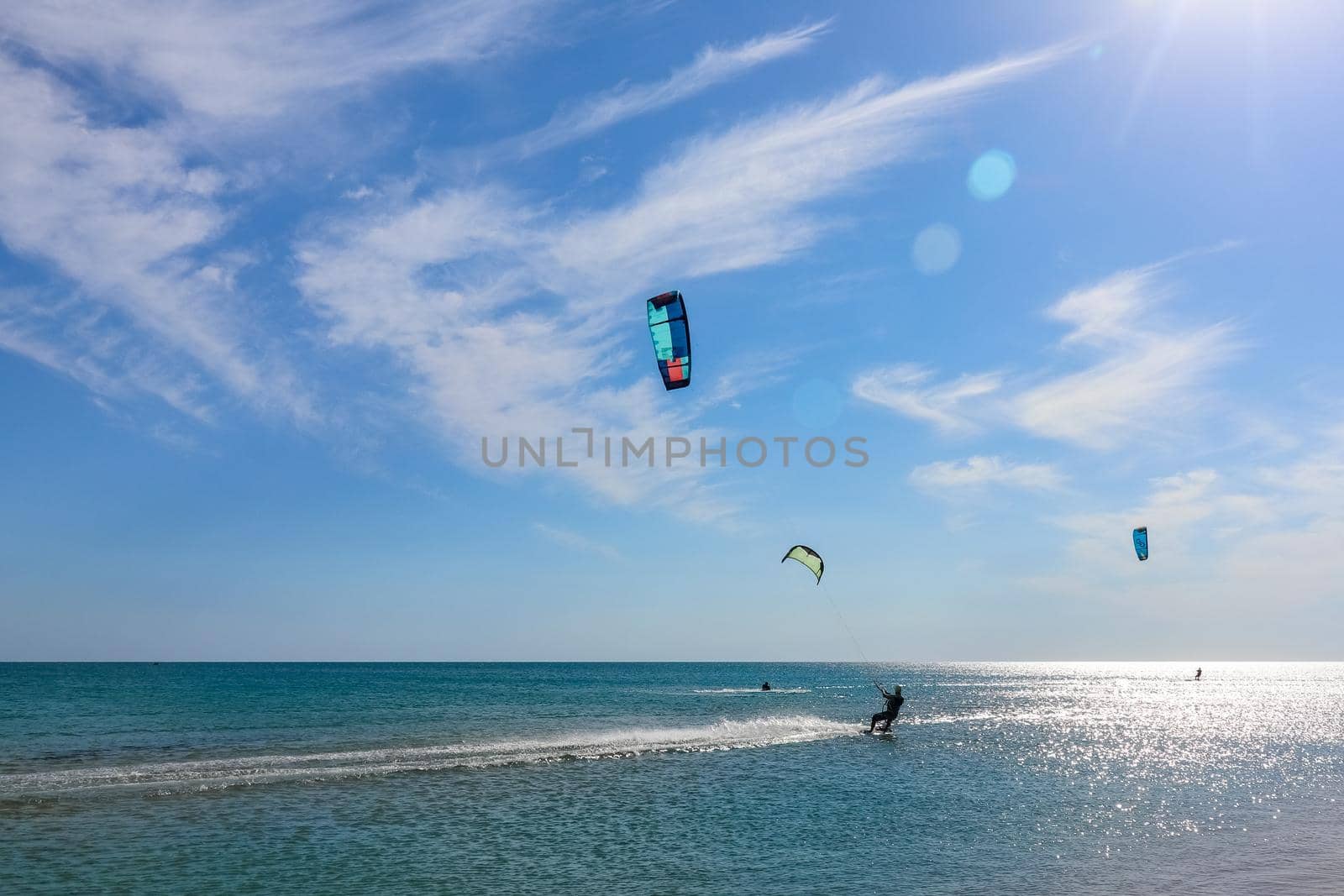 a kitesurfer surfing on the smooth azure water. recreational sport. A Man Rides A Kiteboarding In The Sea Water. extreme sport. High quality photo