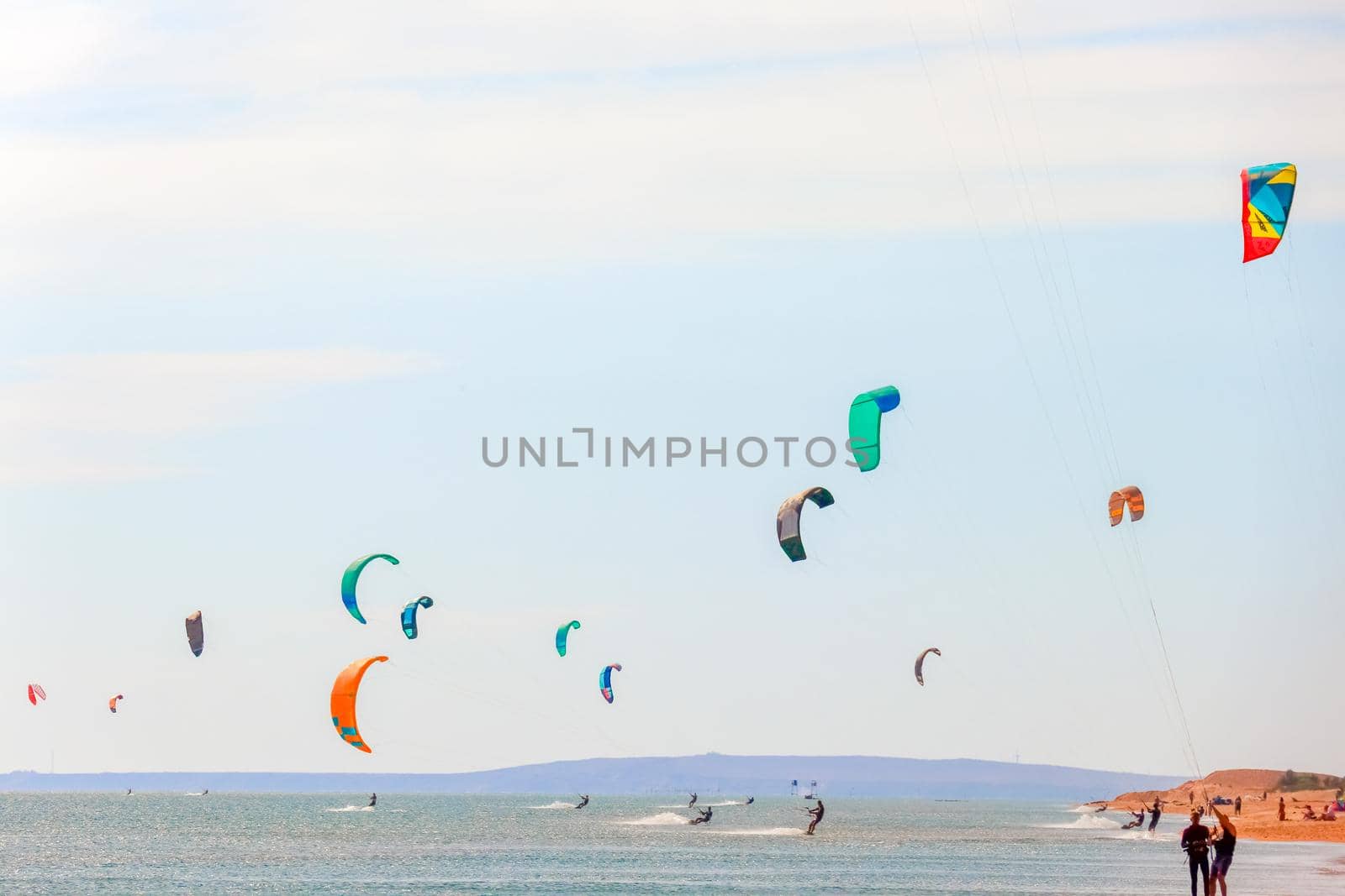 a kitesurfer surfing on the smooth azure water. recreational sport. A Man Rides A Kiteboarding In The Sea Water. extreme sport. High quality photo