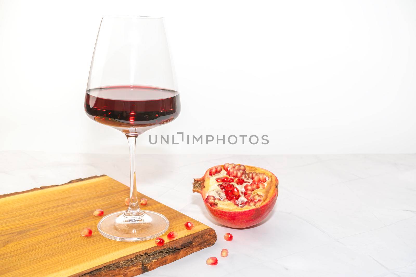 a glass of red wine on a Board with pomegranate. High quality photo