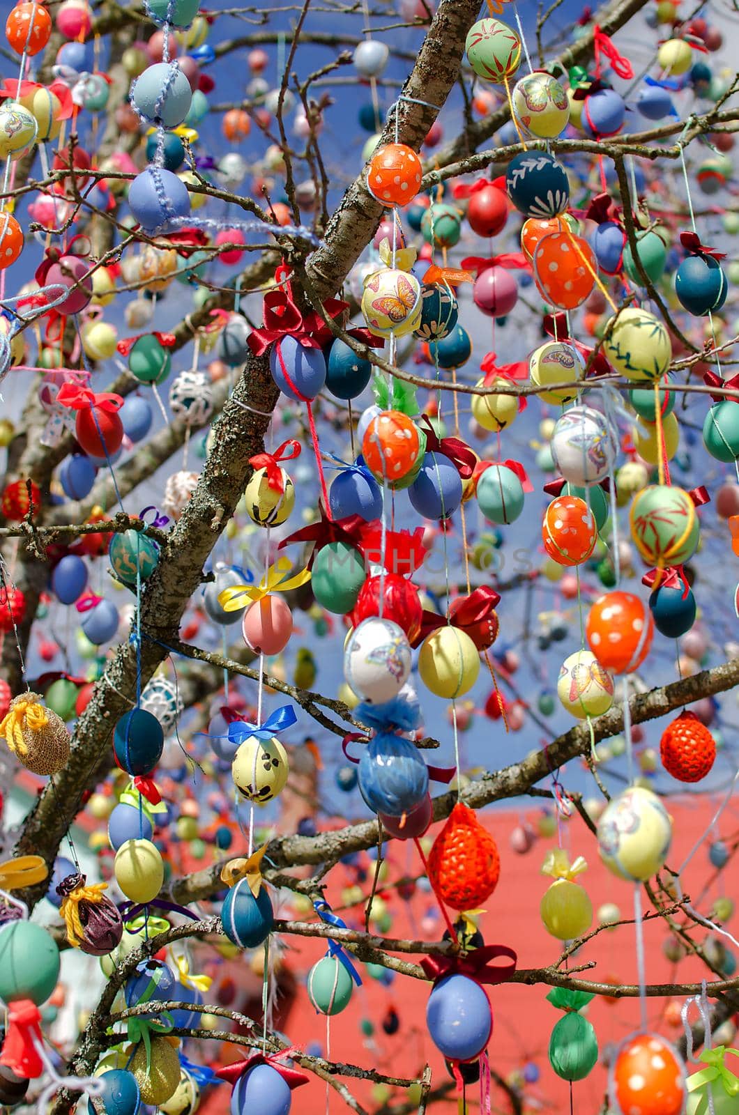 Traditional festive Easter tree. Pretty decorated colored Easter eggs with modern patterns hanging on a tree branch. Stock photo