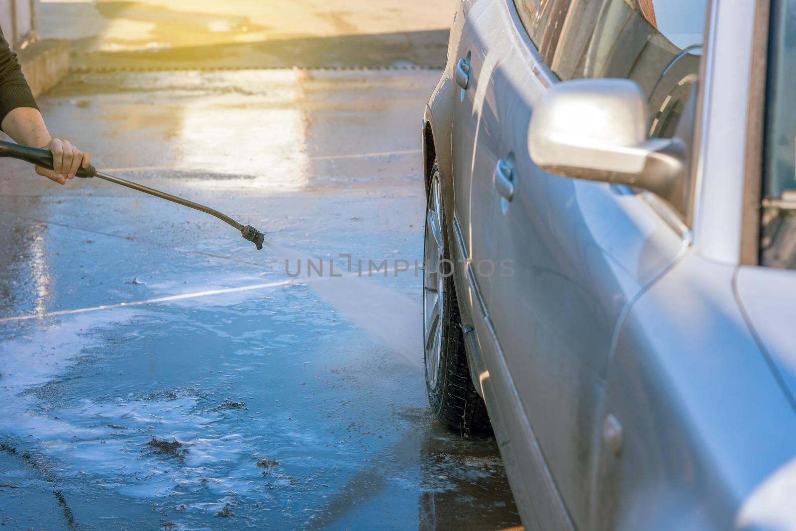 Car washing with flowing water. Outdoor Self Service Cleaning Car Using High Pressure Water