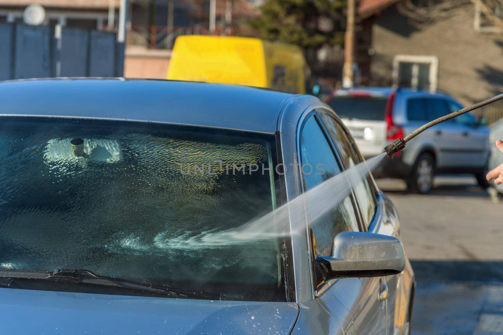 Car washing with flowing water. Outdoor Self Service Cleaning Car Using High Pressure Water