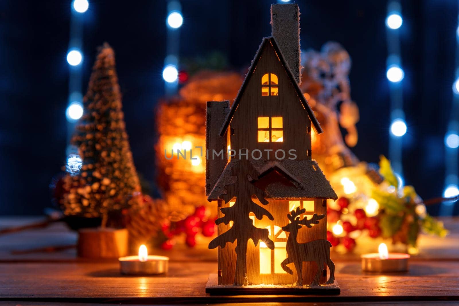 Christmas gingerbread house decoration on defocused lights background.