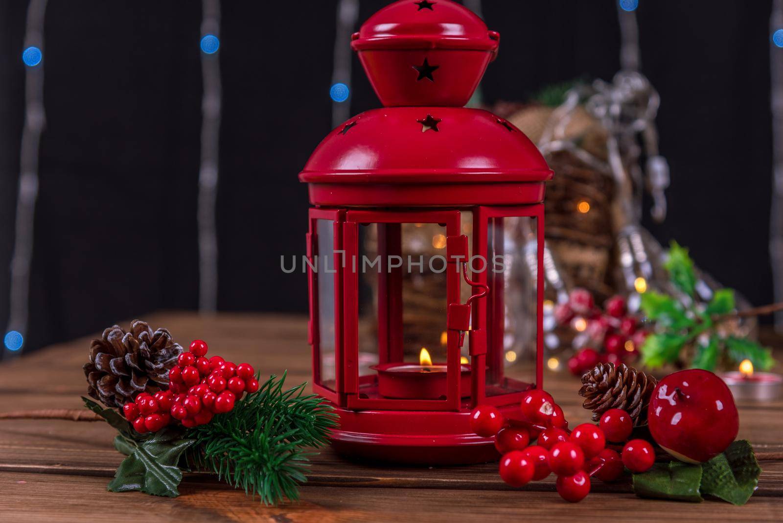 Christmas lantern with candle on defocused lights background.