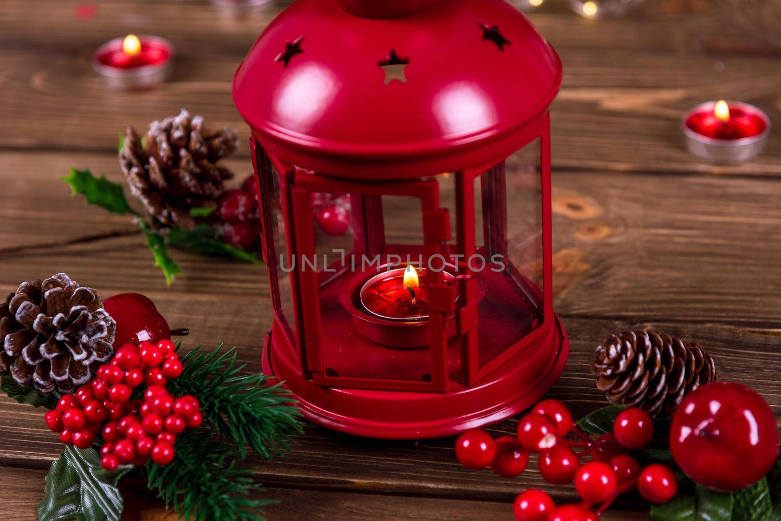 Christmas lantern with candle on defocused lights background.