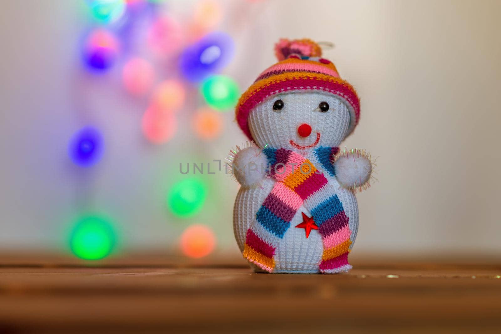 Snowman figurine.Blurry Christmas lights out of focus in the background. Bokeh