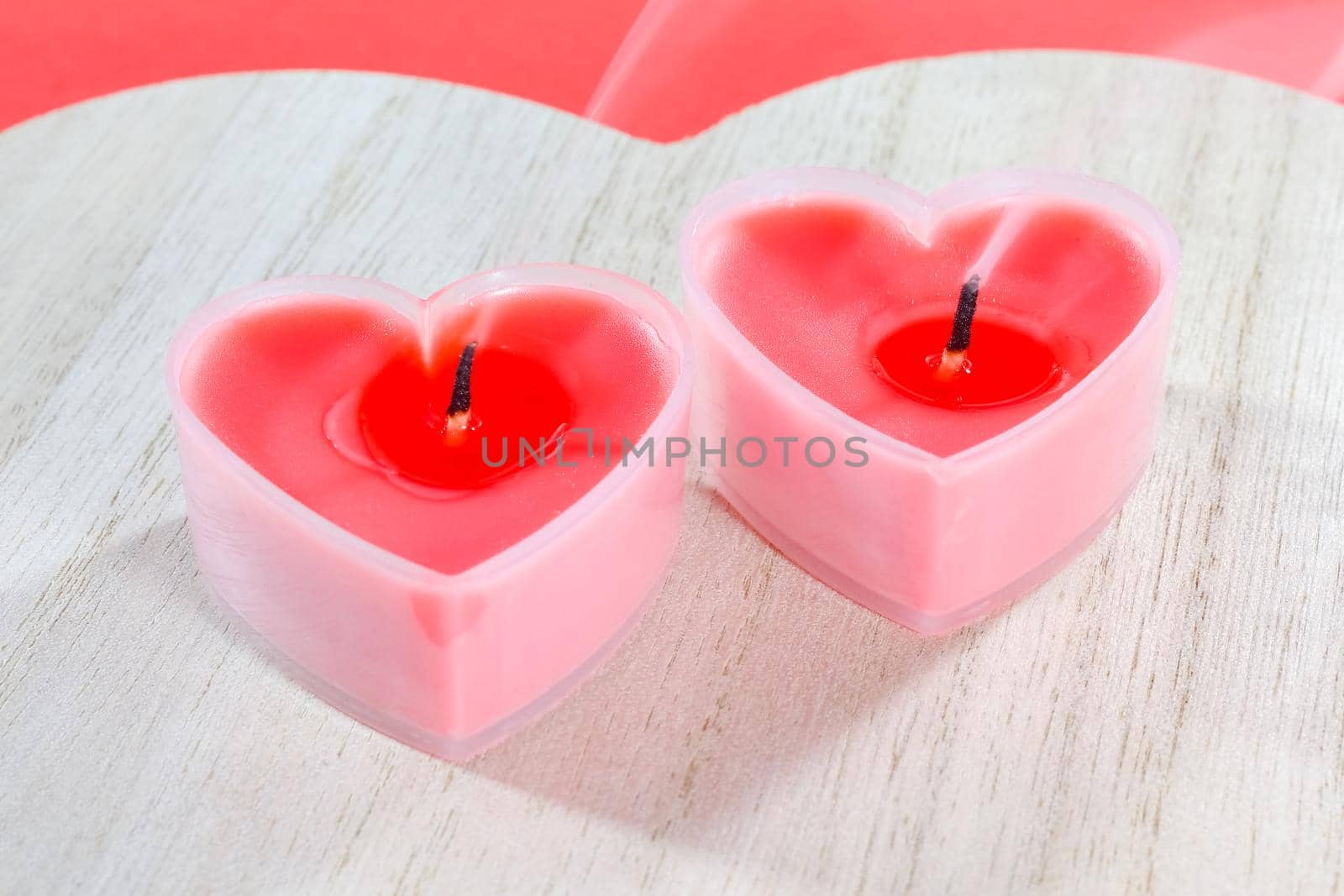 pink candles in the form of a heart on a red background for Valentine's day  by roman112007