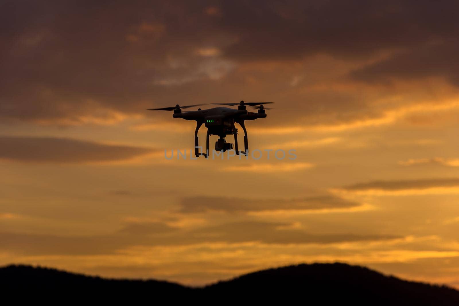 drone quad copter with digital camera at sunset ready to fly for surveillance