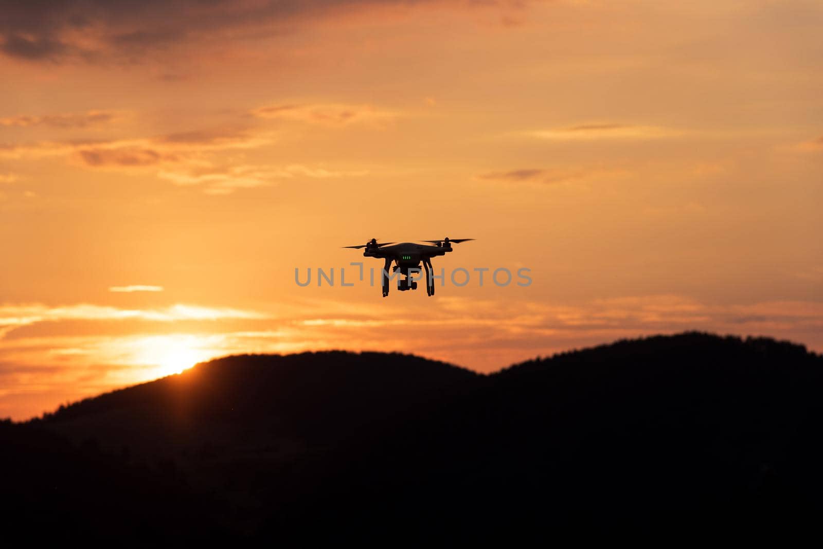 drone quad copter with digital camera at sunset ready to fly for surveillance.