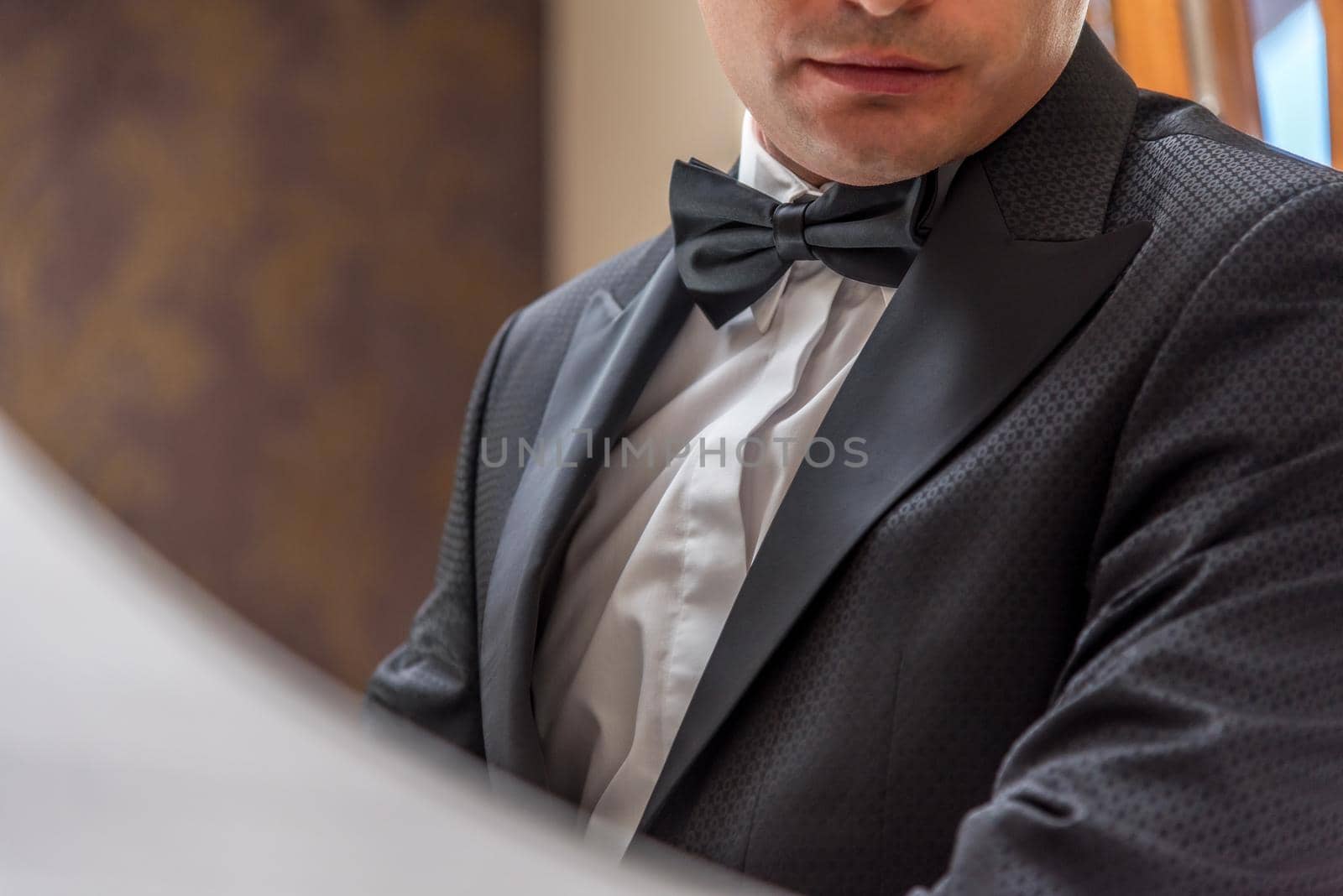 Groom adjusting bow tie