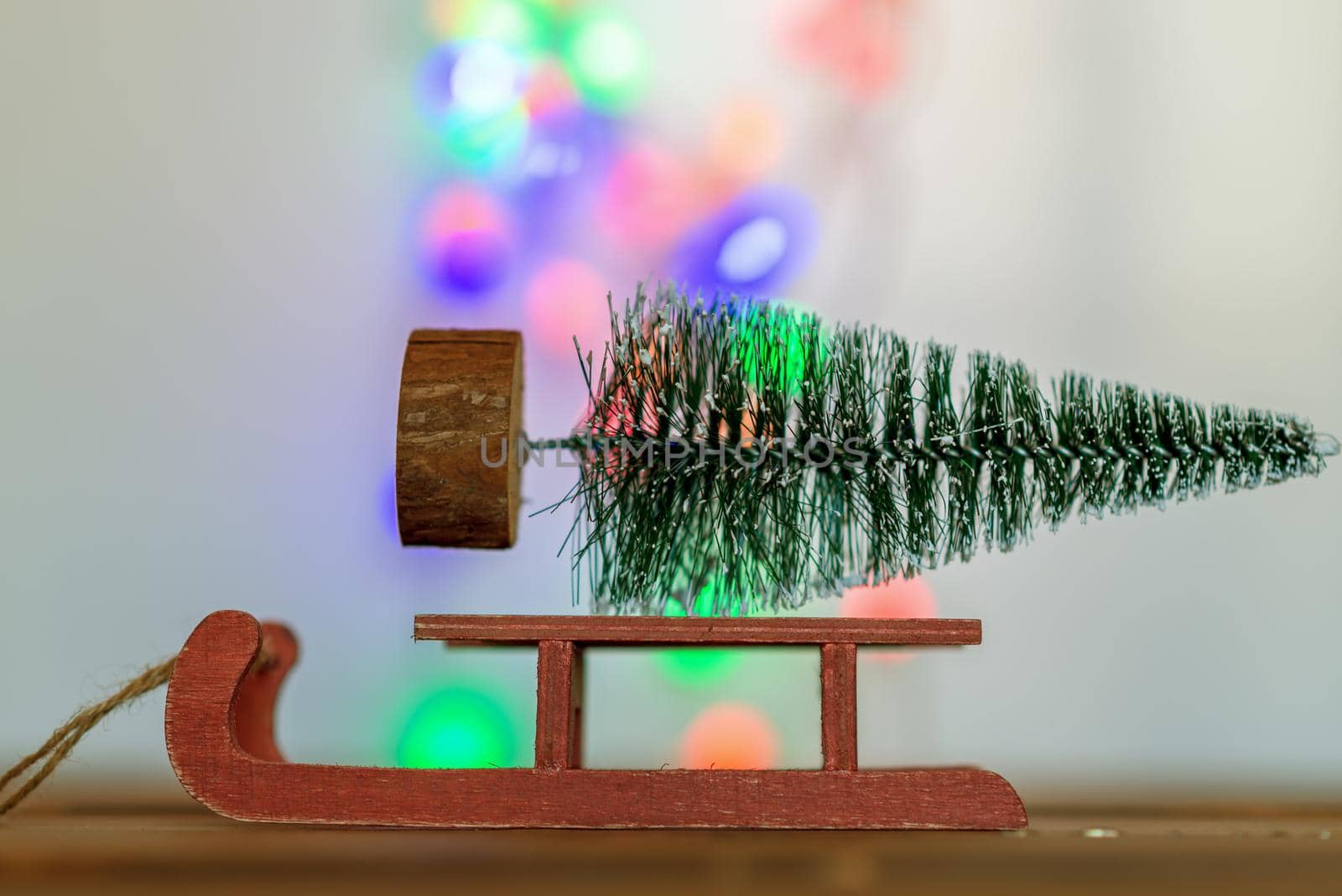 Red sleigh carrying a small Christmas tree in winter