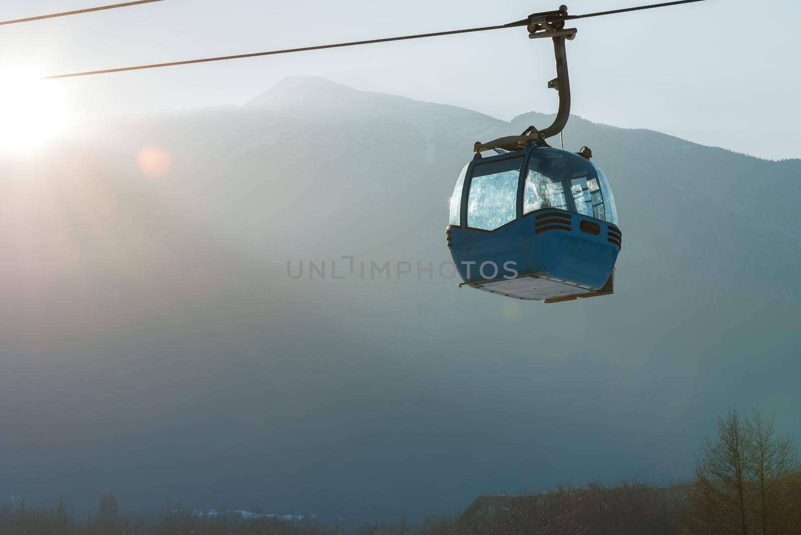 Ropeway and cable car transport system for skiers in sunset