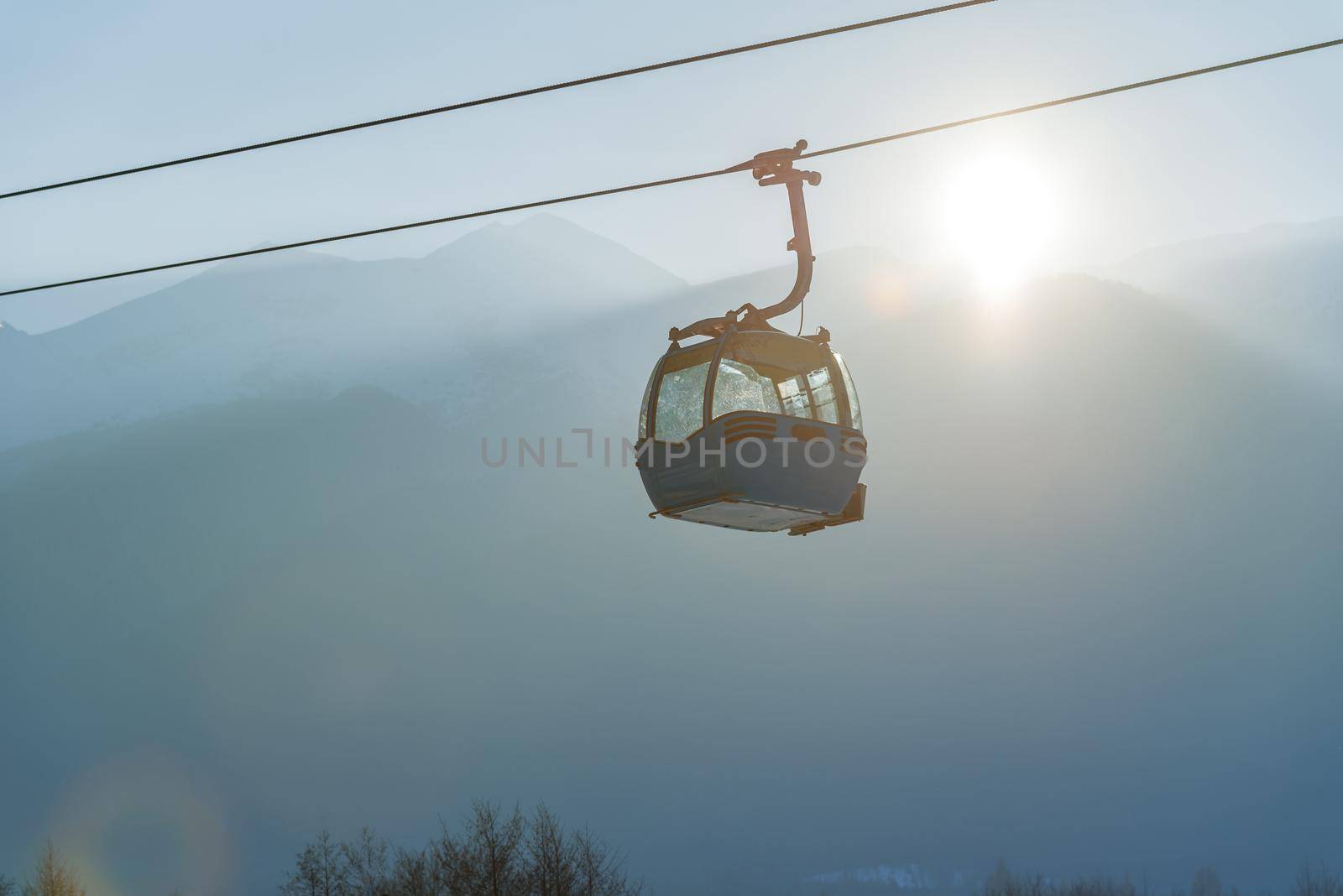 Ropeway and cable car transport system for skiers in sunset