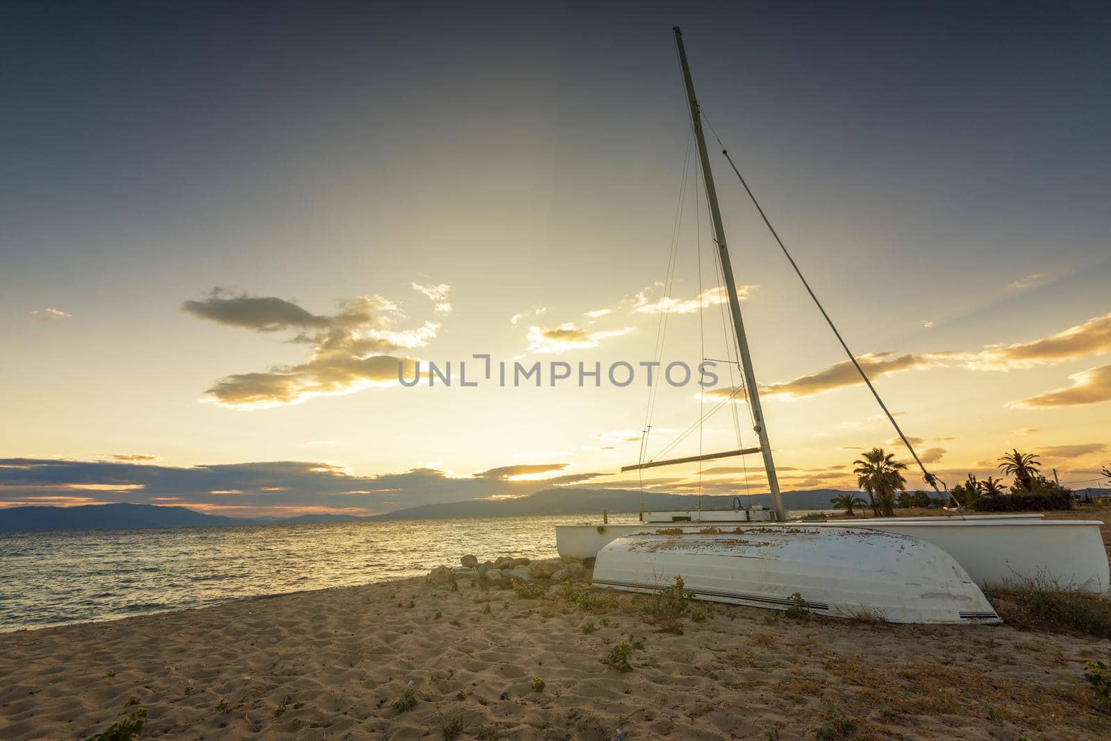 Sailboat on the beach at sunset in Greece