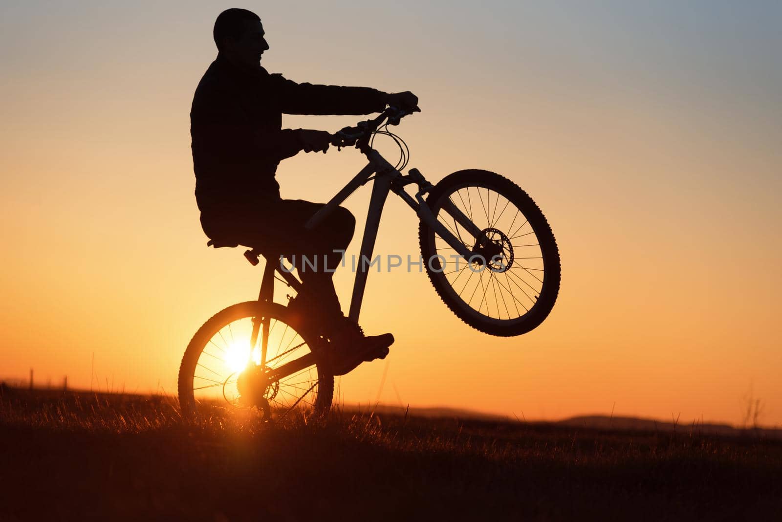 dramatic sunset of silhouette of biker in summer 