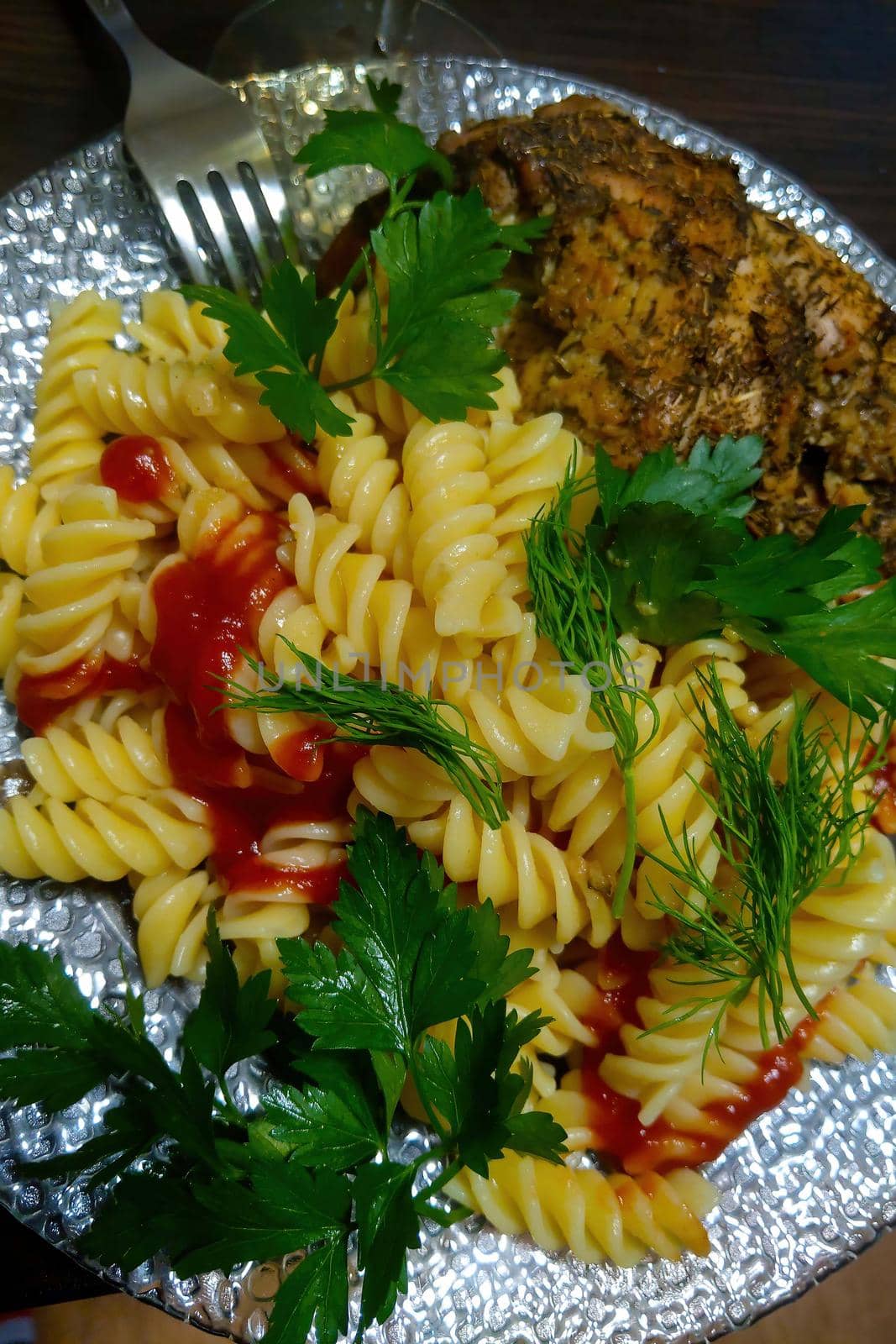 Pasta with chicken pieces and herbs on a white plate. by kip02kas