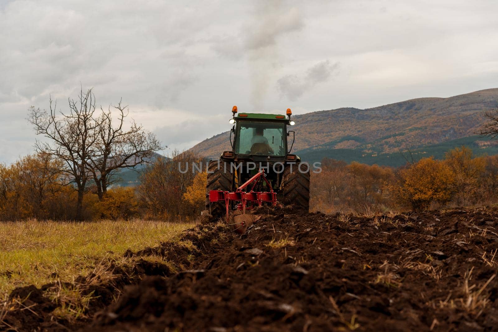Tractor plowing fields. Preparing land for sowing in autumn.