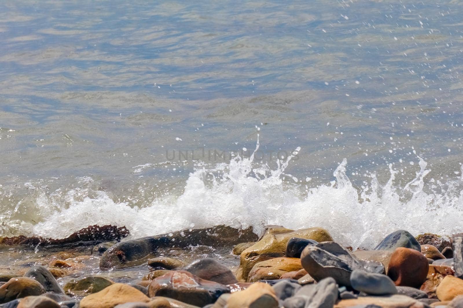 pebbles and stones on the beach. waves and splashes on the shore. High quality photo