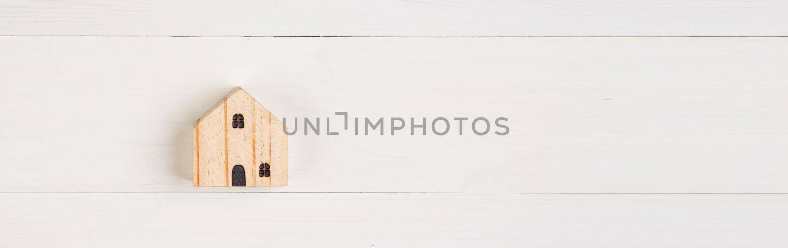 Model home small is wood on wooden background, real estate and investment and tax, mortgage and house, symbol investment for profit of asset, family and loan for residential, copy space.