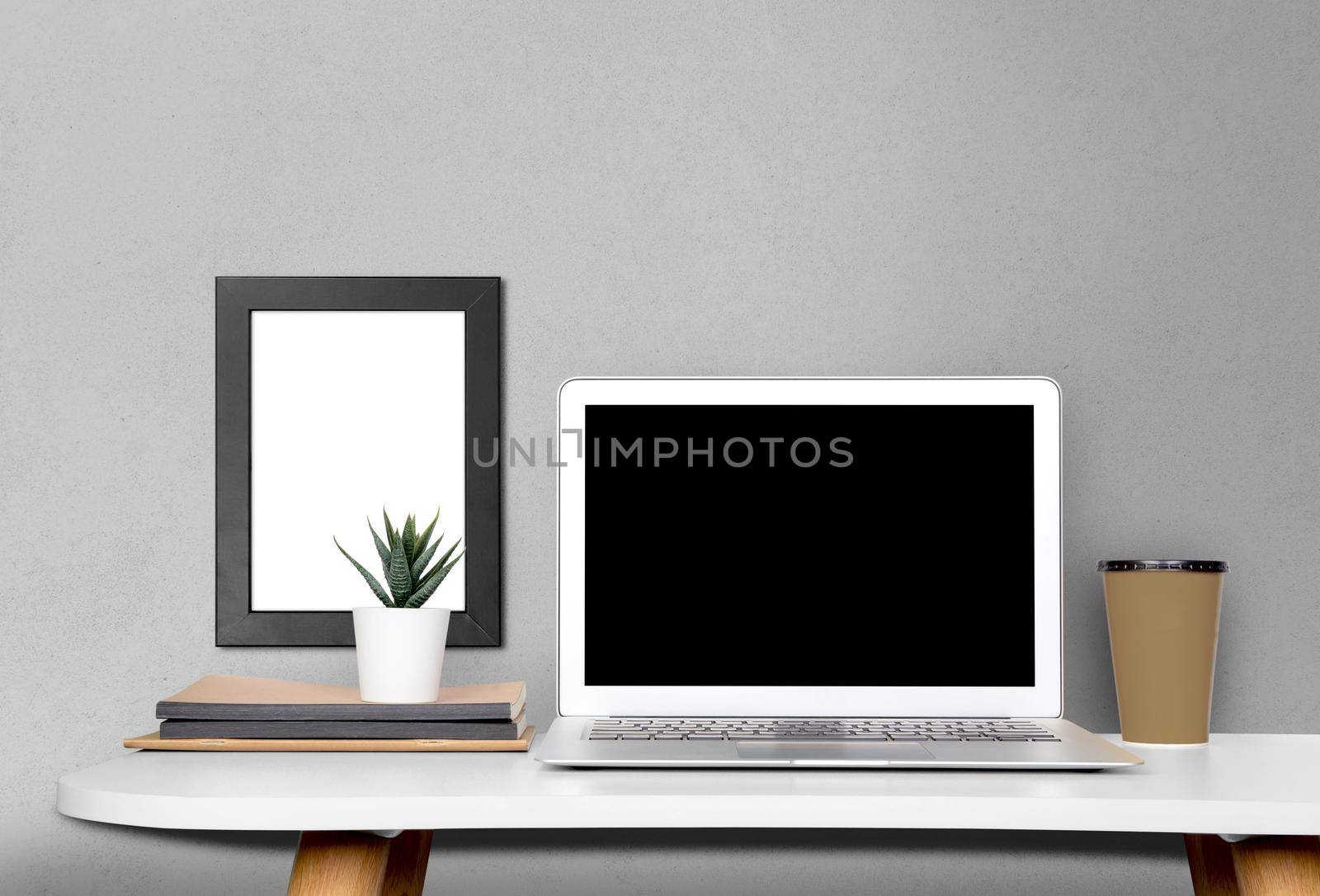 Mockup template laptop computer display screen and picture frame with blank on desk, workplace and office, poster on wall, interior room, indoor, copy space, business and workspace concept.