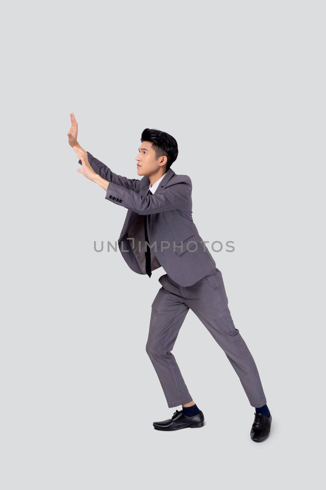 Young asian business man pushing something isolated on white background, businessman strong and with expression difficult, marketing and presentation for success, employee and career job with heavy.