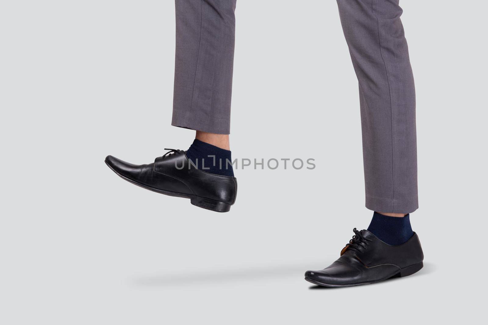 Foot of businessman walking for achievement isolated on white background, leg of leadership moving progress, metaphor and conceptual, copy space, cut out, man standing, business concept.