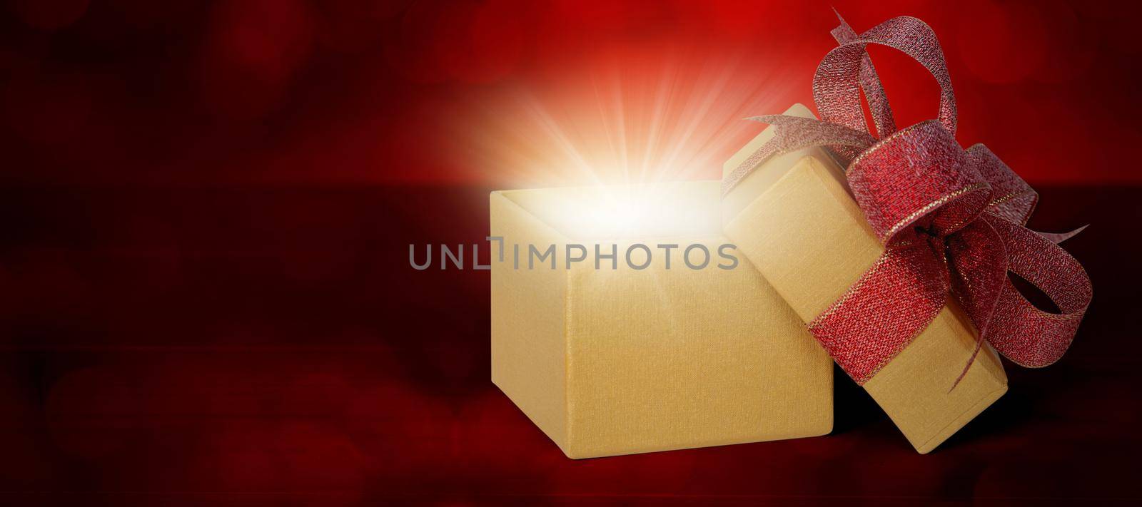 Gold gift box with ribbon open and light blurred bokeh background, present with luxury for love and anniversary with glowing and sparkle in festive, copy space, Valentine day or Christmas concept. by nnudoo