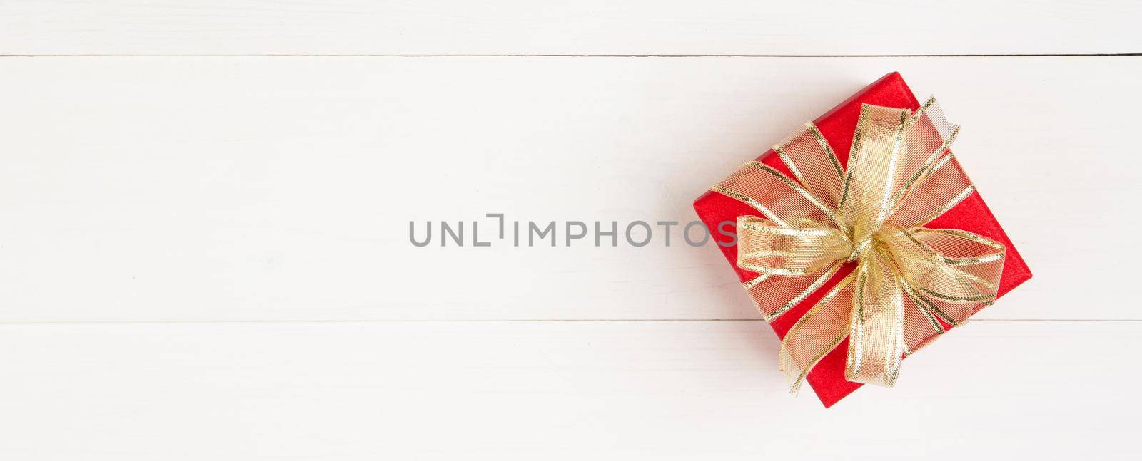 Red gift box on wooden table background, love and romance, presents in celebration and anniversary with surprise on desk, happy birthday, donate and charity, valentine day 14 February concept.