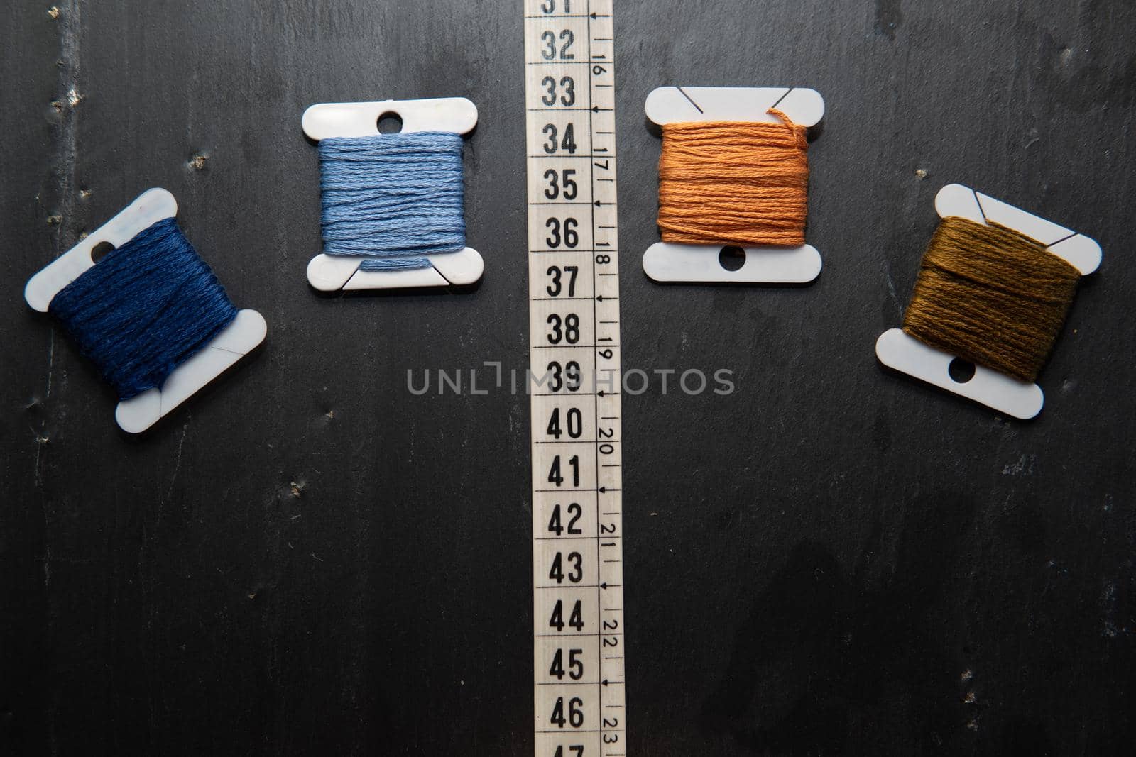 Black background with sewing utensils and a clock