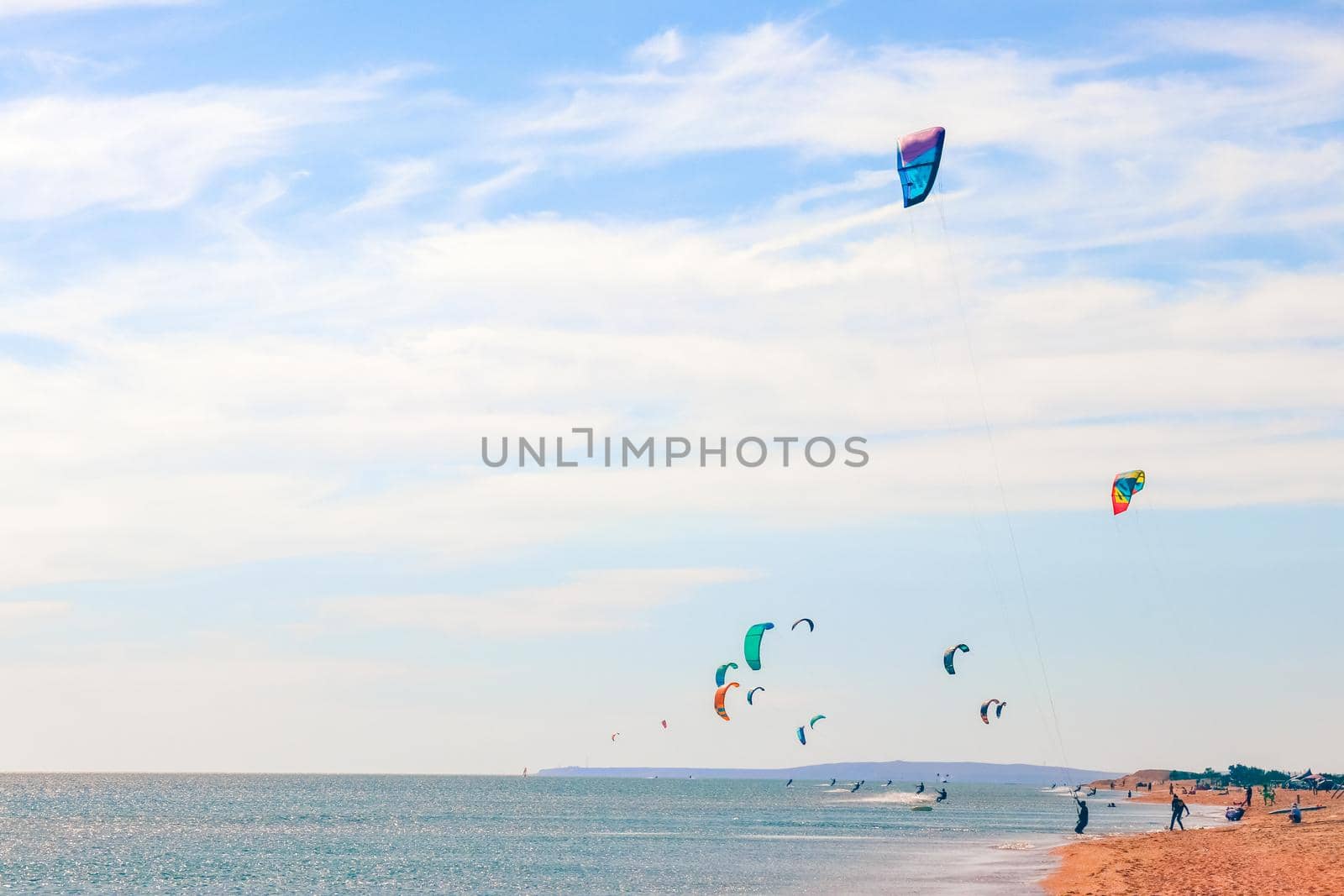 a kitesurfer surfing on the smooth azure water. recreational sport. A Man Rides A Kiteboarding In The Sea Water. extreme sport. Jump by roman112007