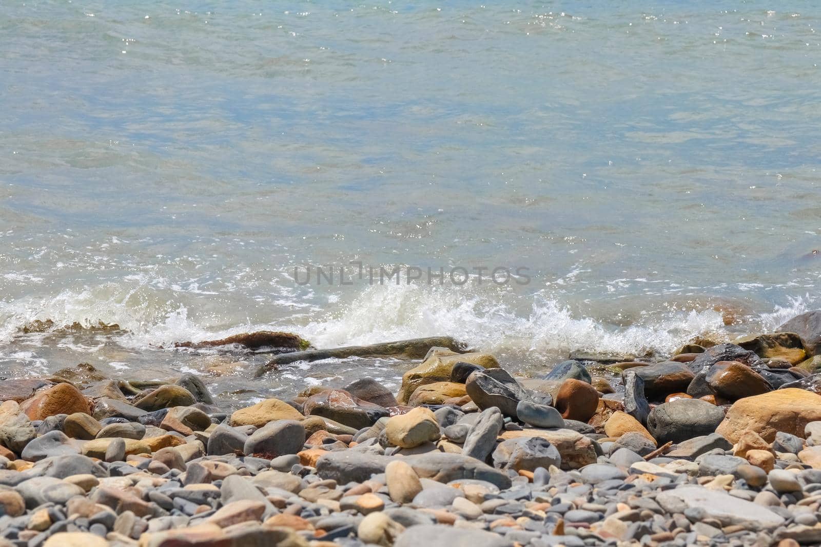 pebbles and stones on the beach. waves and splashes on the shore. High quality photo