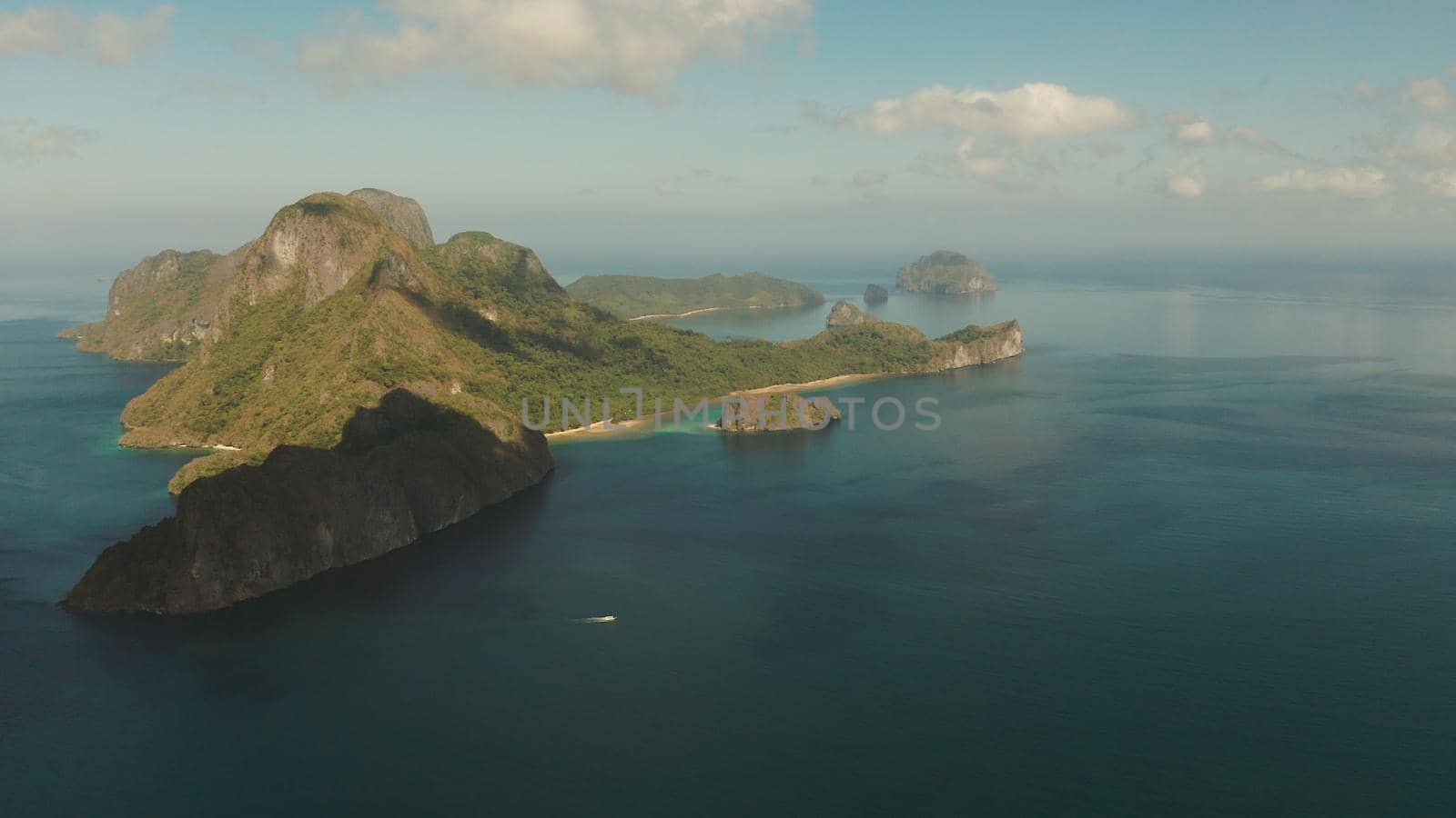 Seascape with tropical bay, rocky islands, ocean blue water, aerial view. islands and mountains covered with tropical forest. El nido, Philippines, Palawan. Tropical Mountain Range