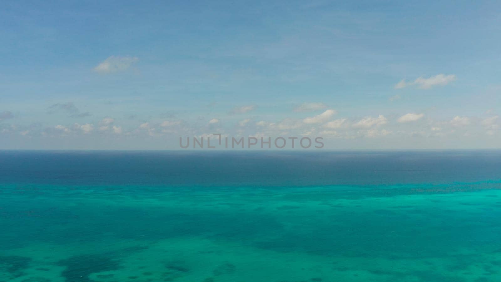 Flying over the sea with turquoise water, atoll and coral reef, aerial view. Balabac, Palawan, Philippines. Summer and travel vacation concept.