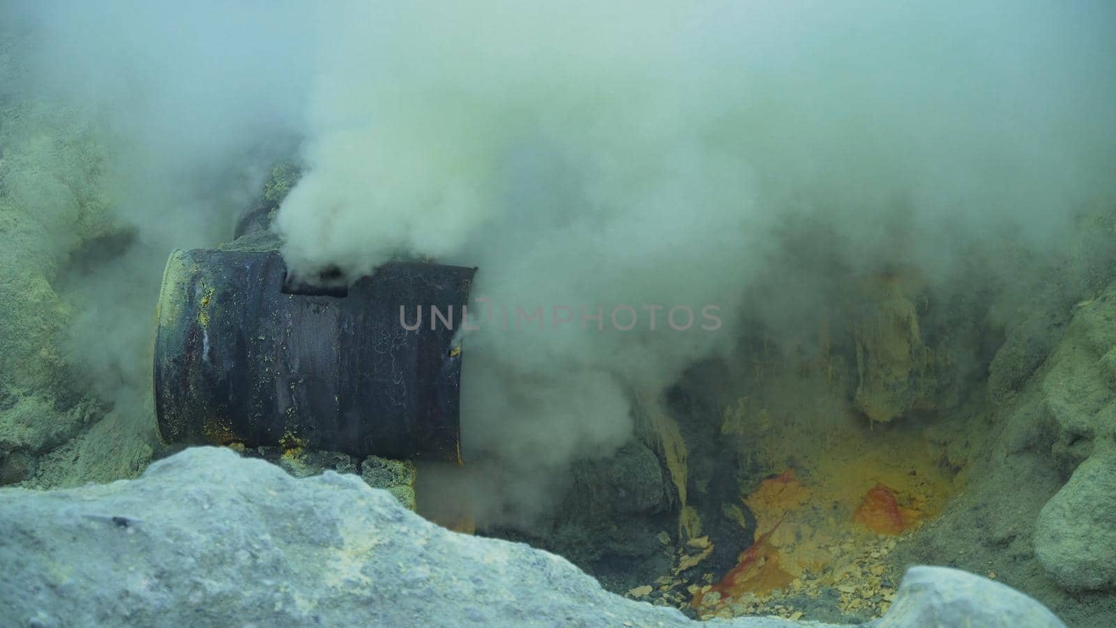 Extraction of sulfur in the crater of a volcano. Sulfur gas, smoke. Kawah Ijen, crater with acidic crater lake where sulfur is mined. Ijen volcano complex is a group of stratovolcanoes in the Banyuwangi Regency of East Java, Indonesia.