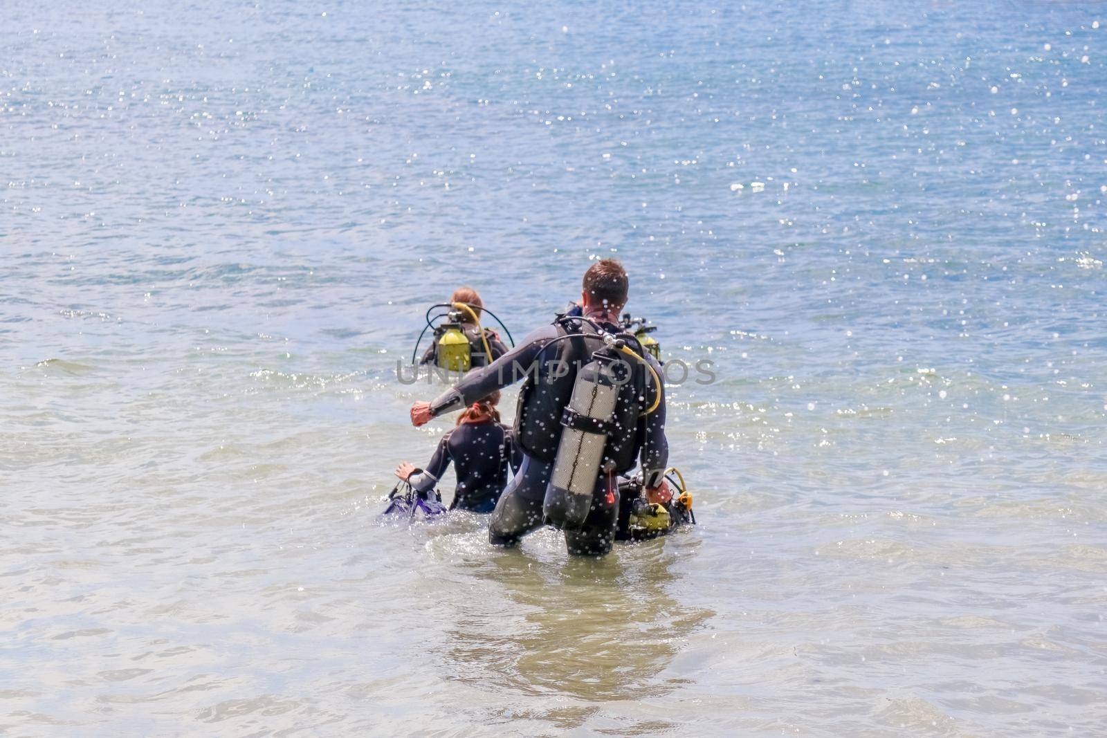 divers enter the water on the beach by roman112007