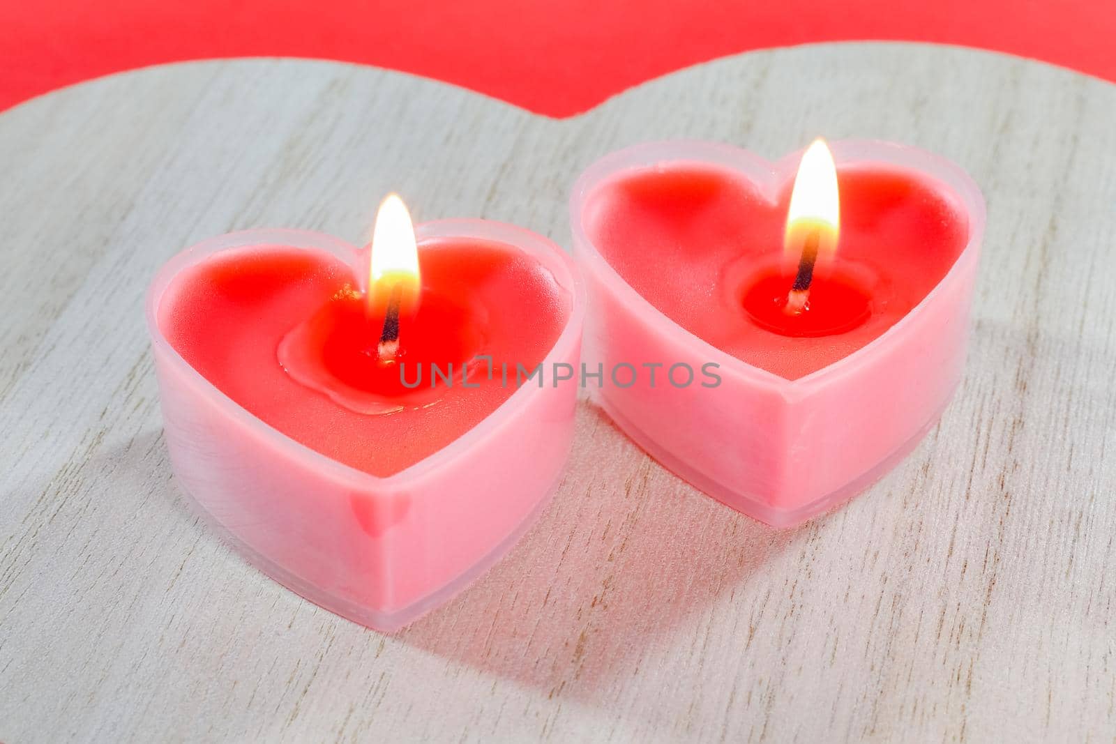 pink candles in the form of a heart on a red background for Valentine's day . High quality photo