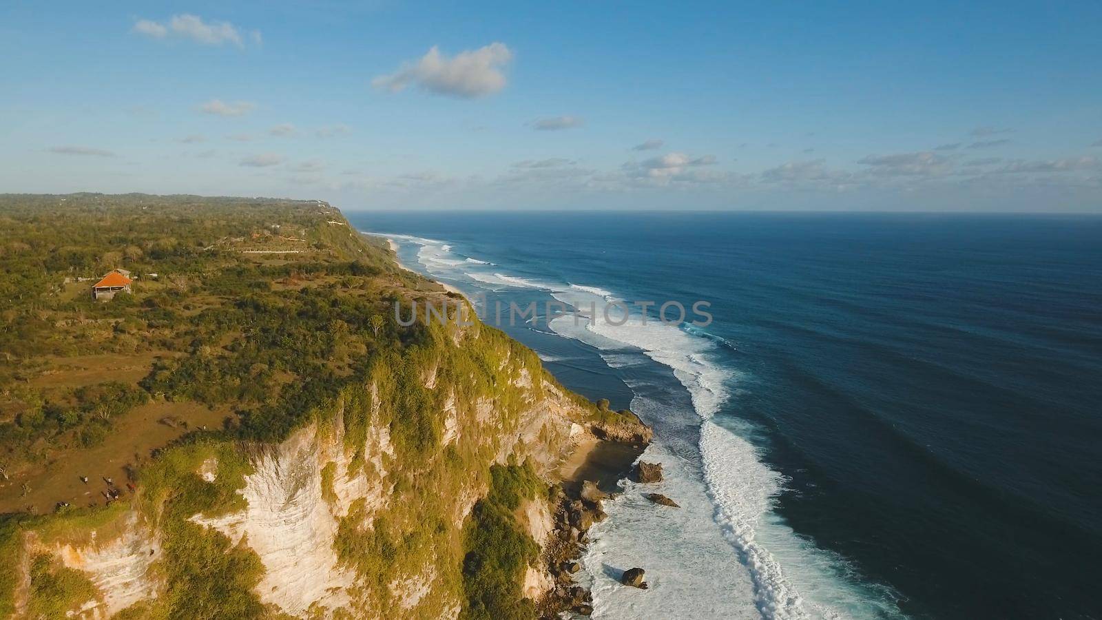Aerial view of sea rocky coast with surf the waves, Bali, Indonesia, Pura Uluwatu cliff. Waves crushing rocky shore. Seascape, rocks, ocean. Travel concept.