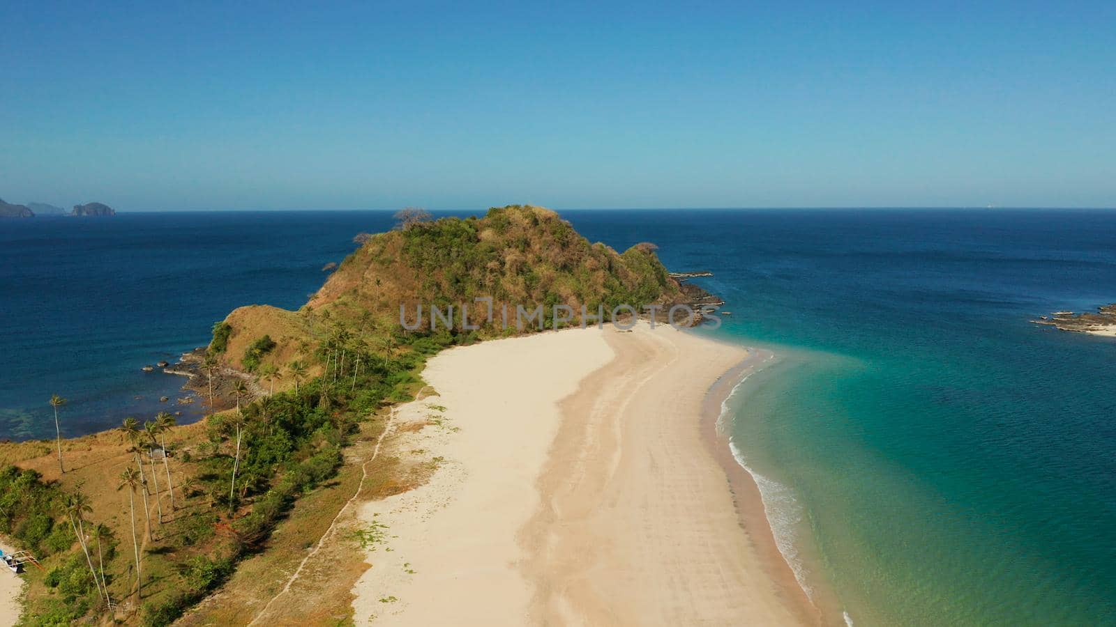 Blue sea and tropical beach, aerial drone. Nacpan, El Nido, Palawan, Philippine Islands. Seascape with tropical beach and islands. Summer and travel vacation concept