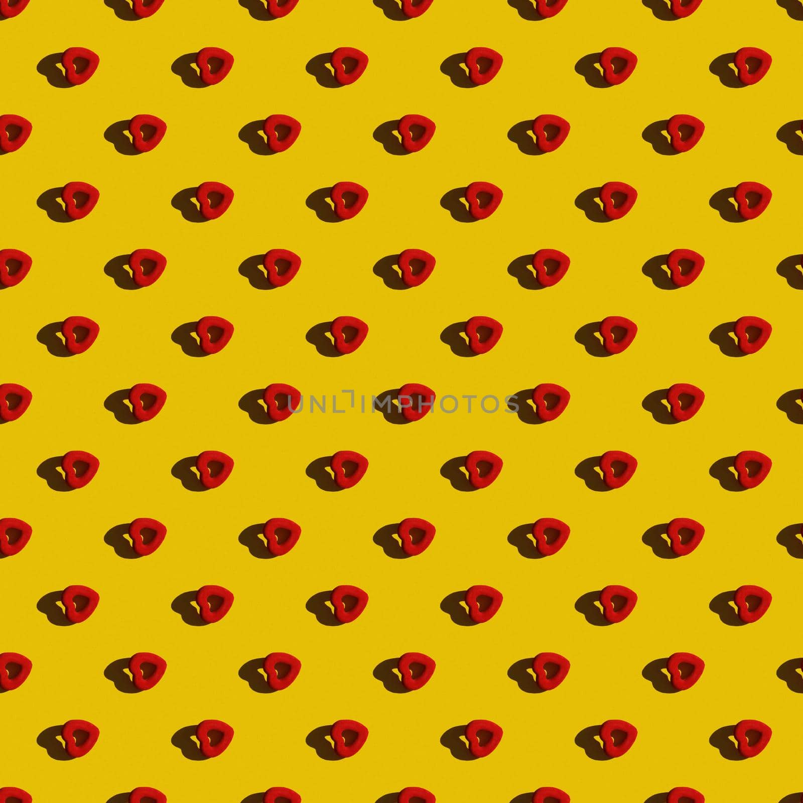 Template. Red heart in a row diagonally on a yellow background. Top view, flat lay, layout. Romantic colorful pattern.