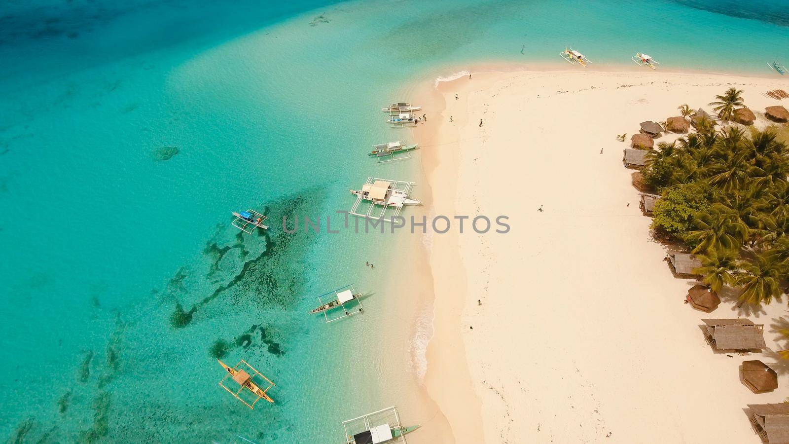 Aerial view of beautiful tropical island Daco with white sand beach. View of a nice tropical beach from the air. Beautiful sky, sea, resort. Seascape: Ocean and beautiful beach paradise. Philippines. Travel concept.