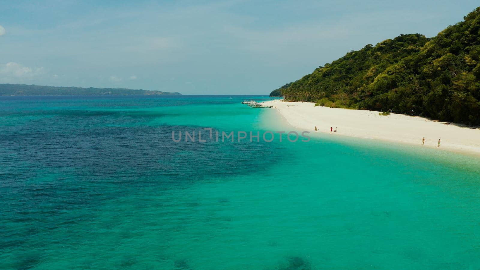 Sandy tropical beach with tourists and blue clear sea. Summer and travel vacation concept. Boracay, Philippines. Seascape with beach on tropical island. Puka shell beach