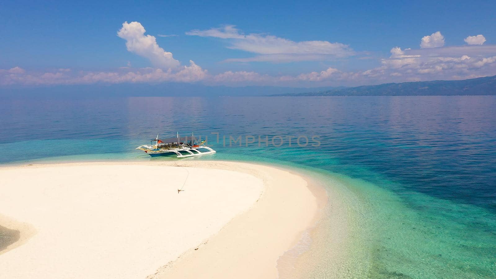 Perfect beach with blue water and white sand. Boat off the coast of a tropical island. Summer and travel vacation concept. Digyo Island, Philippines. Holiday and vacation concept.