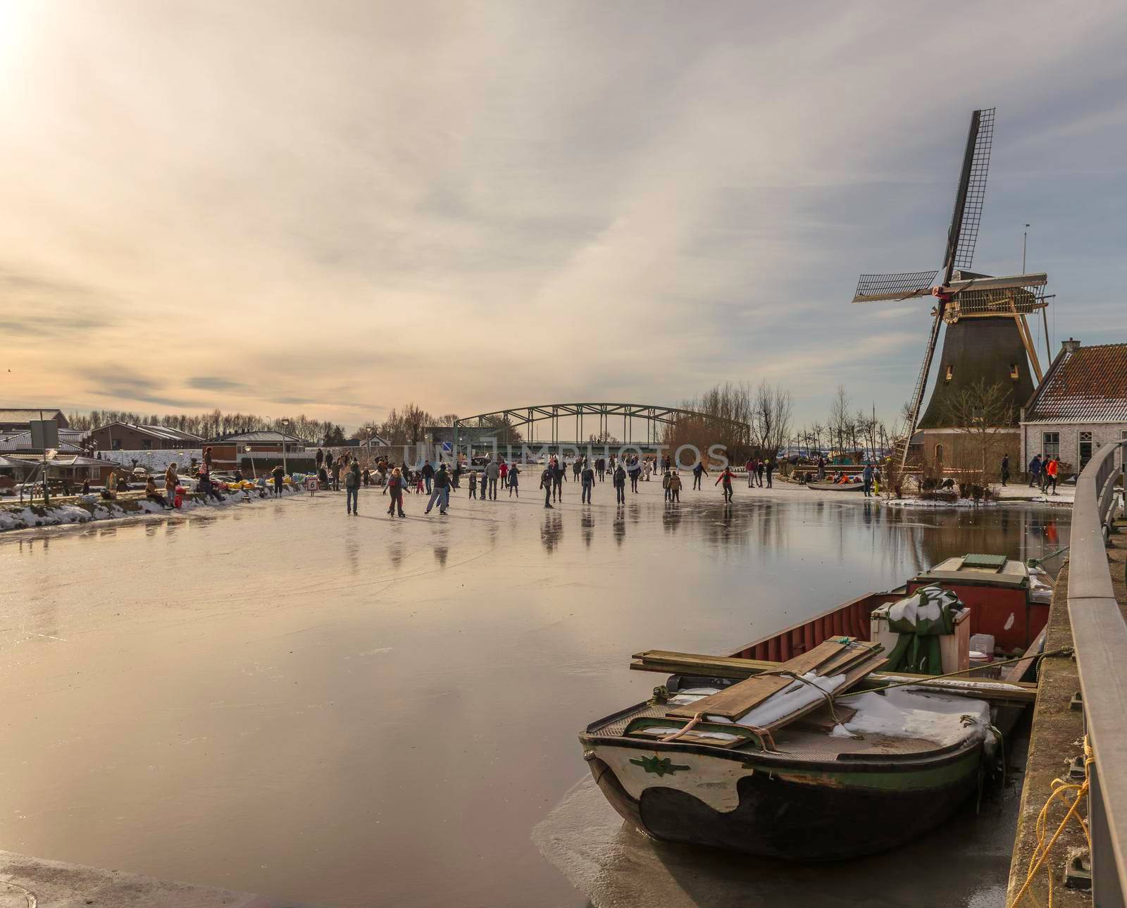 Schipluiden,Holland,14-feb-2021:people skating on the canal near the windmill, it has been years ago that is was so cold in Holland, people can skate