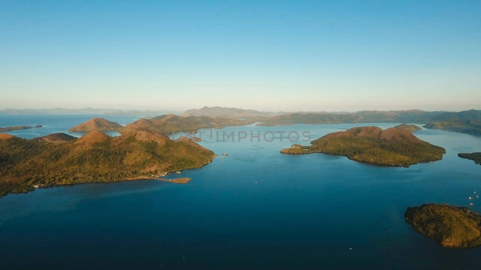 Aerial view: beach, tropical island, sea bay and lagoon, mountains with rainforest, Busuanga, Palawan. Seascape, tropical landscape. Azure water of lagoon Philippines