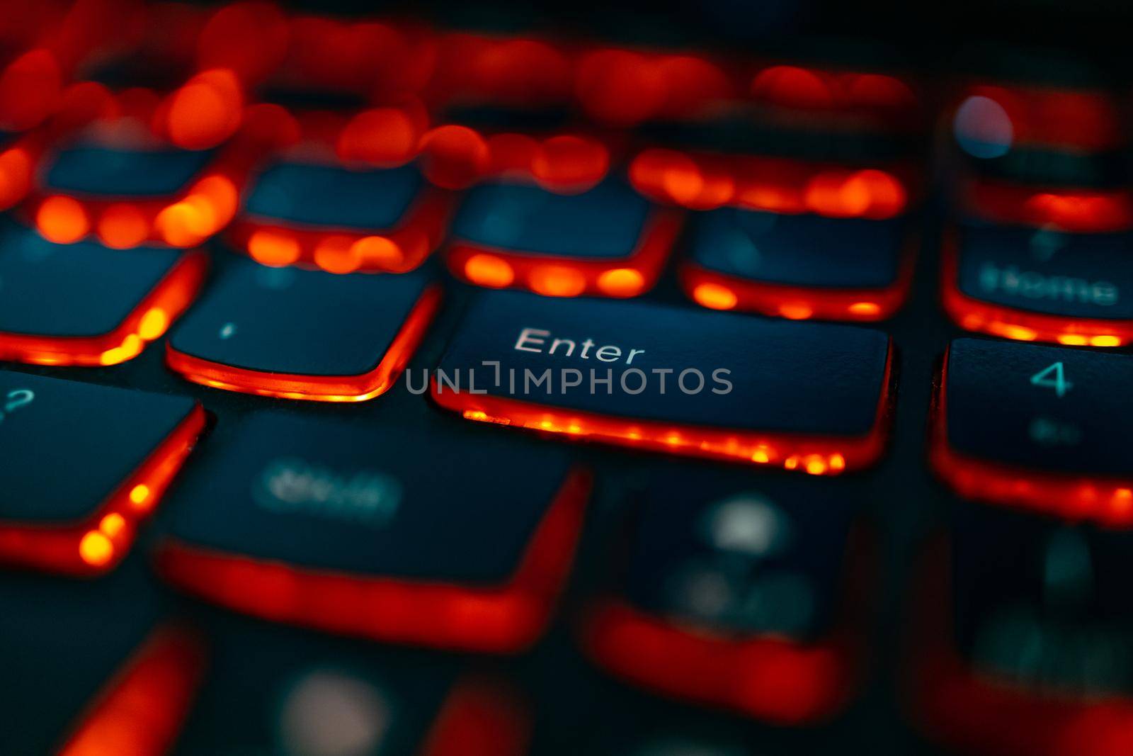 Old laptop with red highlighted keyboard with focus on Enter key